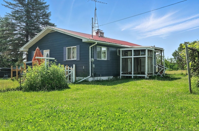 8698 Big Stone Lake Rd, Evart, MI 49631 - back of house featuring a chimney, a sunroom, and a metal roof