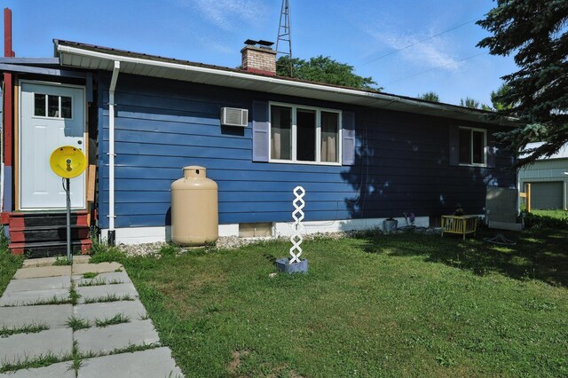 8698 Big Stone Lake Rd, Evart, MI 49631 - view of side of property with entry steps, a chimney, a yard, and a wall mounted AC
