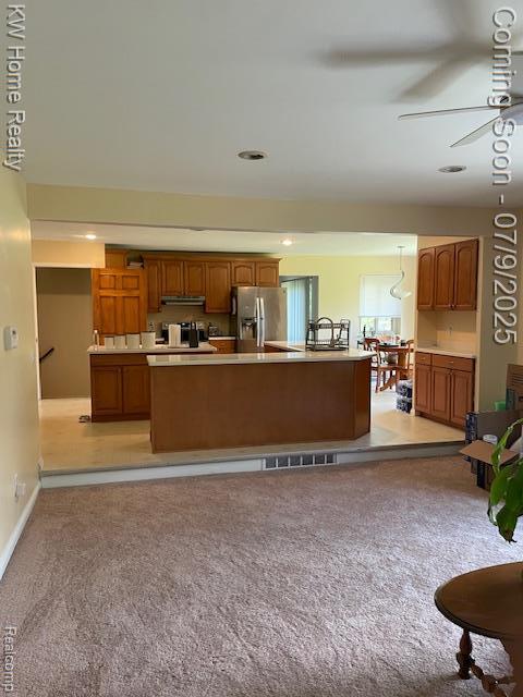 24890 Arden Park Dr, Farmington Hills, MI 48336 - kitchen with stainless steel refrigerator with ice dispenser, light colored carpet, light countertops, under cabinet range hood, and brown cabinetry