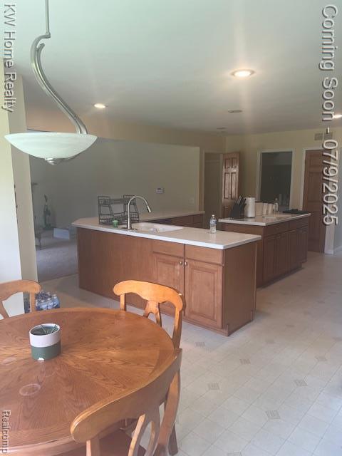 24890 Arden Park Dr, Farmington Hills, MI 48336 - kitchen with a center island, light countertops, light flooring, and brown cabinetry