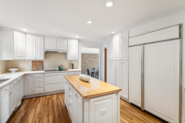 15665 Portage Rd, Vicksburg, MI 49097 - kitchen featuring paneled built in fridge, wooden counters, black electric stovetop, white cabinetry, and light wood finished floors