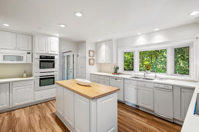 15665 Portage Rd, Vicksburg, MI 49097 - kitchen with white appliances, wooden counters, arched walkways, light wood finished floors, and white cabinetry