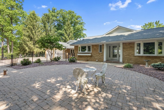 15665 Portage Rd, Vicksburg, MI 49097 - view of front of home with brick siding, a patio, curved driveway, and roof with shingles