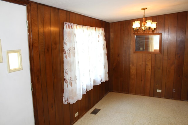 2786 Dinius Rd, Tecumseh, MI 49286 - unfurnished dining area featuring healthy amount of natural light, a chandelier, wooden walls, and light carpet
