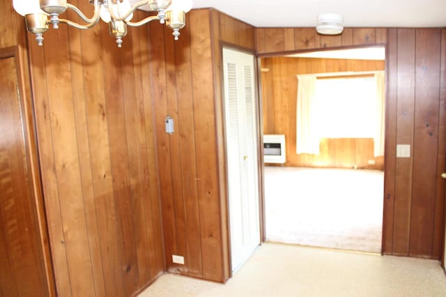 2786 Dinius Rd, Tecumseh, MI 49286 - hallway featuring a chandelier, wooden walls, light colored carpet, and heating unit