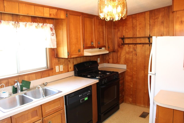 2786 Dinius Rd, Tecumseh, MI 49286 - kitchen with black appliances, under cabinet range hood, light countertops, brown cabinetry, and a chandelier
