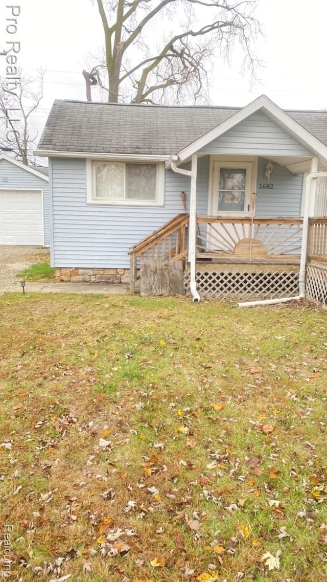 1682 Beatrice St, Westland, MI 48186 - view of front of property with a detached garage, roof with shingles, a front lawn, and driveway