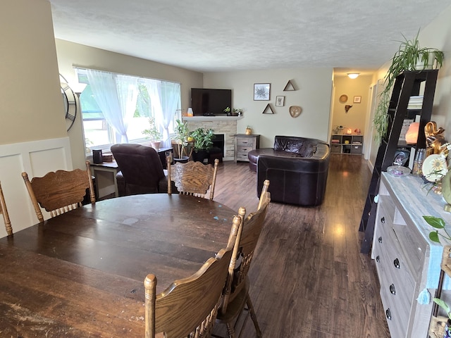 3330 Bradford St NE, Grand Rapids, MI 49525 - dining area featuring a fireplace, dark wood-style floors, and a textured ceiling