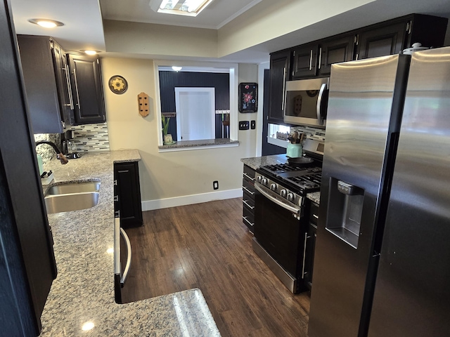 3330 Bradford St NE, Grand Rapids, MI 49525 - kitchen with stainless steel appliances, light stone countertops, dark cabinets, dark wood finished floors, and backsplash