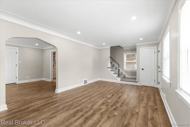 10320 Roxbury St, Detroit, MI 48224 - empty room with arched walkways, wood finished floors, crown molding, stairs, and recessed lighting