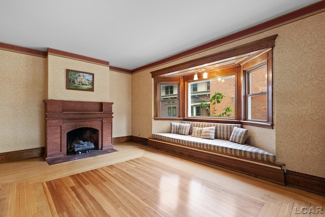 305 W Chicago Blvd, Tecumseh, MI 49286 - unfurnished living room featuring light wood finished floors, wallpapered walls, ornamental molding, and a fireplace with flush hearth