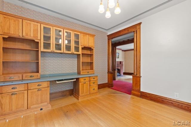 305 W Chicago Blvd, Tecumseh, MI 49286 - unfurnished office with wallpapered walls, light wood-style flooring, built in desk, and decorative columns