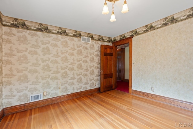 305 W Chicago Blvd, Tecumseh, MI 49286 - spare room with wood finished floors and wallpapered walls