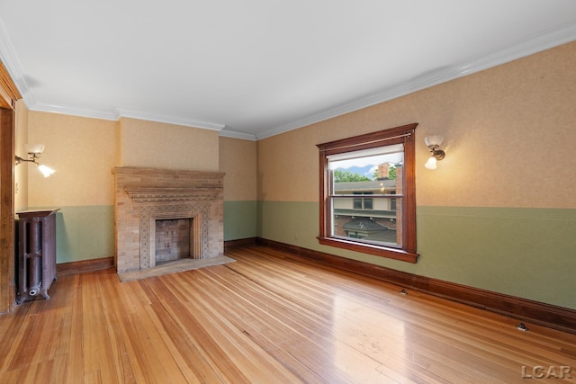 305 W Chicago Blvd, Tecumseh, MI 49286 - unfurnished living room with hardwood / wood-style flooring, a fireplace, radiator heating unit, and crown molding