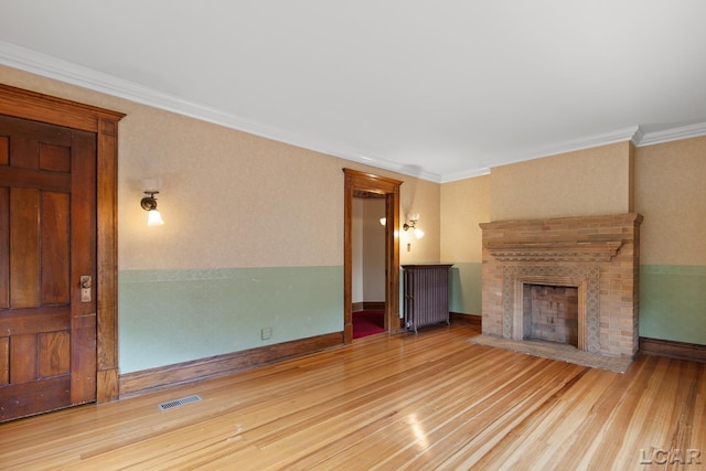 305 W Chicago Blvd, Tecumseh, MI 49286 - unfurnished living room with a brick fireplace, wood finished floors, and crown molding