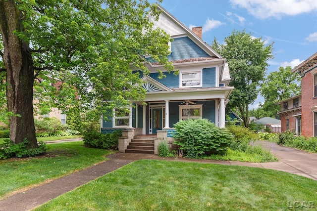 305 W Chicago Blvd, Tecumseh, MI 49286 - view of front of house featuring covered porch, a front yard, a chimney, and a ceiling fan