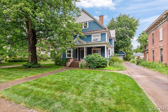 305 W Chicago Blvd, Tecumseh, MI 49286 - traditional style home featuring covered porch, a chimney, a front yard, and a garage