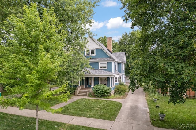 305 W Chicago Blvd, Tecumseh, MI 49286 - view of front of property with a porch, roof with shingles, a chimney, a front yard, and driveway