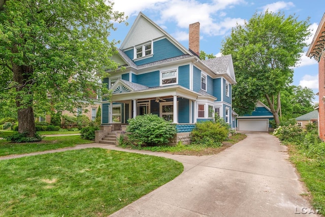 305 W Chicago Blvd, Tecumseh, MI 49286 - view of front of home featuring covered porch, a chimney, a detached garage, a front yard, and an outdoor structure