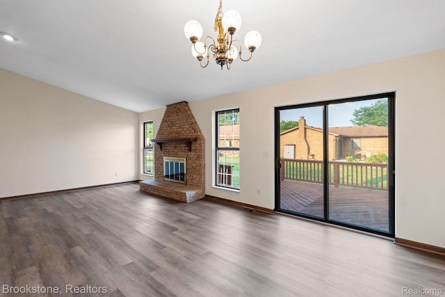 37746 Juniper Dr, Sterling Heights, MI 48310 - unfurnished living room featuring a chandelier, wood finished floors, a brick fireplace, and vaulted ceiling