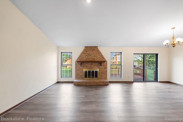 37746 Juniper Dr, Sterling Heights, MI 48310 - unfurnished living room with a chandelier, wood finished floors, and a brick fireplace