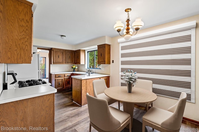 37746 Juniper Dr, Sterling Heights, MI 48310 - kitchen featuring a chandelier, light countertops, wood finished floors, and a peninsula