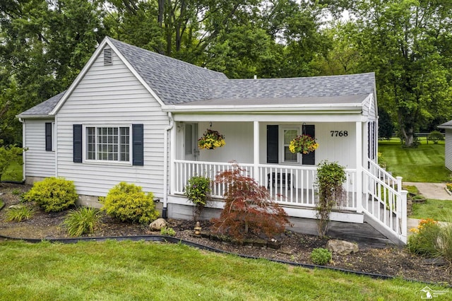 7768 Summerfield Rd, Lambertville, MI 48144 - view of front of house with a porch, roof with shingles, a front yard, and view of wooded area