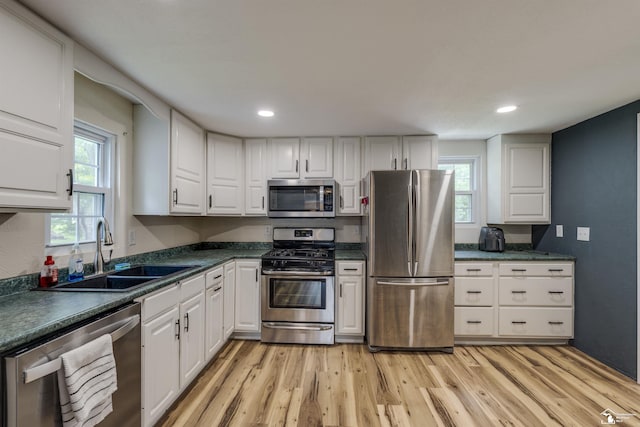 7768 Summerfield Rd, Lambertville, MI 48144 - kitchen featuring appliances with stainless steel finishes, light wood-type flooring, white cabinetry, dark countertops, and recessed lighting