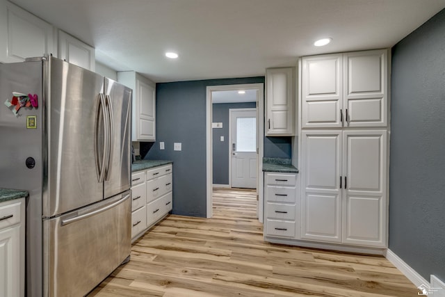 7768 Summerfield Rd, Lambertville, MI 48144 - kitchen featuring freestanding refrigerator, dark countertops, light wood-style flooring, recessed lighting, and a textured wall