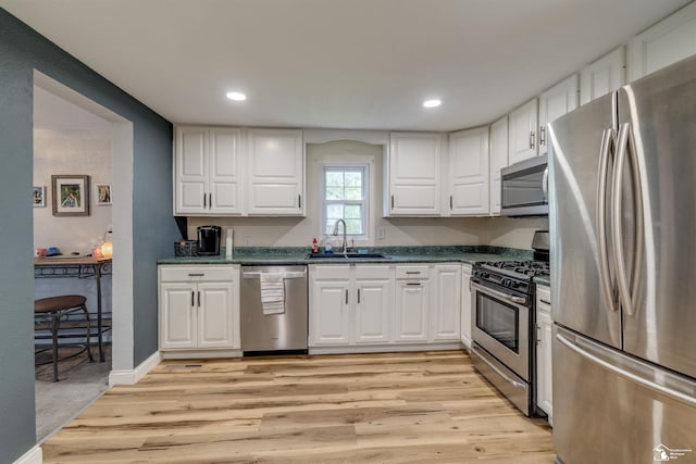 7768 Summerfield Rd, Lambertville, MI 48144 - kitchen featuring stainless steel appliances, dark countertops, light wood-type flooring, white cabinetry, and recessed lighting