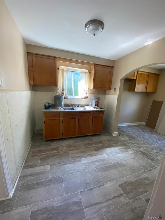 8063 Yolanda St, Detroit, MI 48234 - kitchen with brown cabinetry, arched walkways, and light countertops