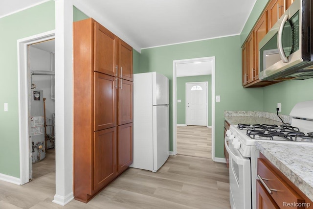 25615 Miracle Dr, Madison Heights, MI 48071 - kitchen with white appliances, water heater, light wood finished floors, light countertops, and brown cabinets