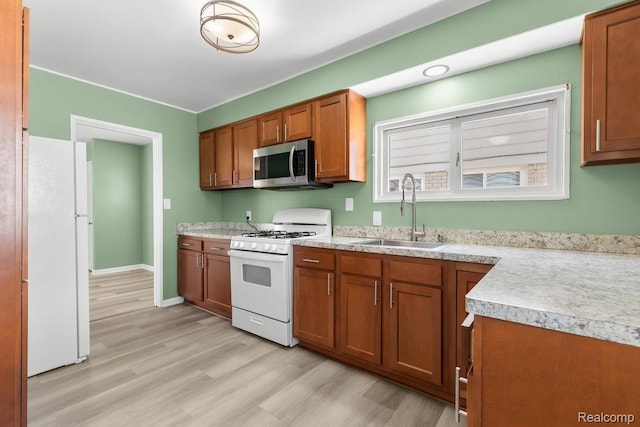 25615 Miracle Dr, Madison Heights, MI 48071 - kitchen featuring white appliances, brown cabinetry, light wood-style floors, and light countertops