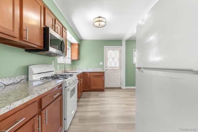 25615 Miracle Dr, Madison Heights, MI 48071 - kitchen with white appliances, brown cabinets, light countertops, and light wood-style floors