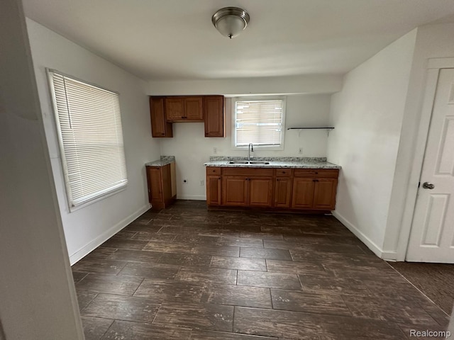 5030 Hereford St, Detroit, MI 48224 - kitchen with brown cabinets, dark wood-style flooring, and light stone countertops