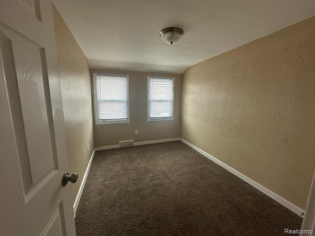 5030 Hereford St, Detroit, MI 48224 - spare room with dark colored carpet and a textured wall