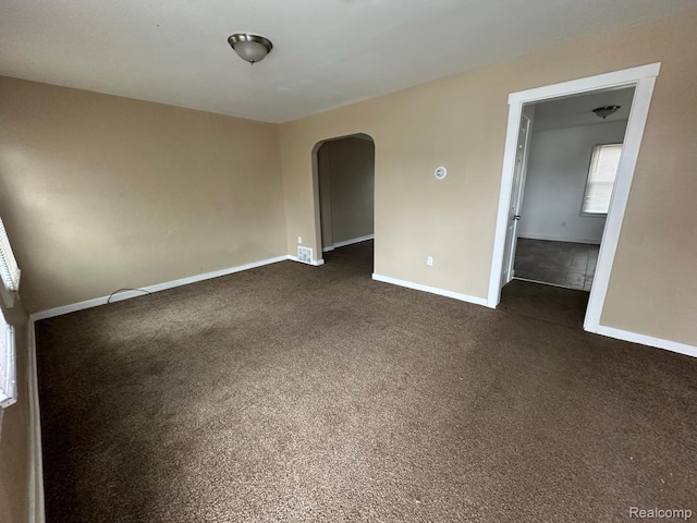5030 Hereford St, Detroit, MI 48224 - empty room with arched walkways and dark carpet
