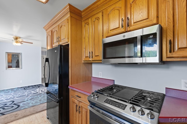 4100 Hunt Rd, Adrian, MI 49221 - kitchen featuring appliances with stainless steel finishes, a ceiling fan, light colored carpet, brown cabinets, and light floors