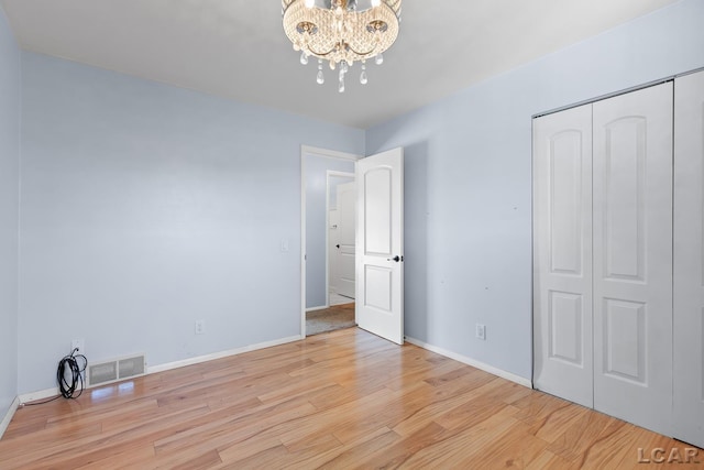4100 Hunt Rd, Adrian, MI 49221 - unfurnished bedroom featuring wood finished floors, a closet, and a chandelier