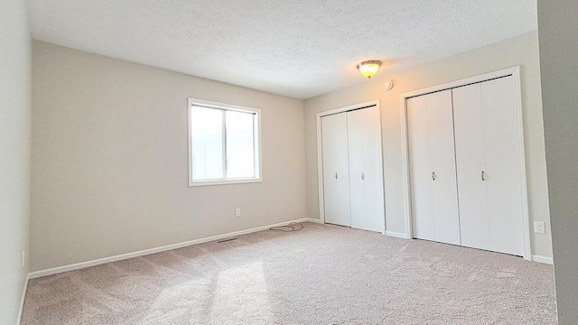 4763 Weston Ave, Kalamazoo, MI 49006 - unfurnished bedroom featuring two closets, carpet floors, and a textured ceiling
