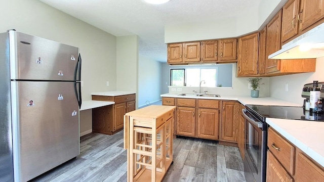 4763 Weston Ave, Kalamazoo, MI 49006 - kitchen with appliances with stainless steel finishes, under cabinet range hood, light wood finished floors, and light countertops