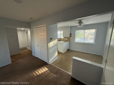 8160 Crestview Dr, Sterling Heights, MI 48312 - kitchen with white cabinets, ceiling fan, and light countertops