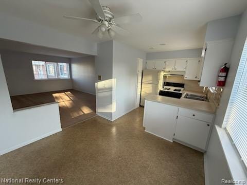 8160 Crestview Dr, Sterling Heights, MI 48312 - kitchen with white stove, ceiling fan, white cabinets, light countertops, and under cabinet range hood