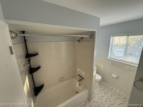8160 Crestview Dr, Sterling Heights, MI 48312 - bathroom featuring tile walls, shower / washtub combination, wainscoting, and tile patterned floors