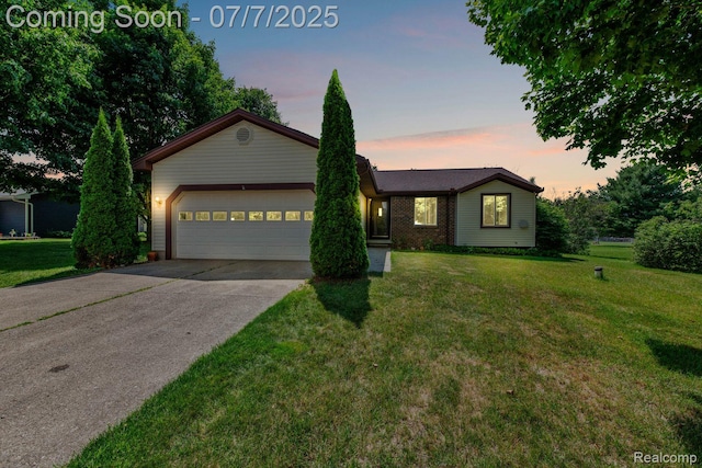 3447 Woodvalley Dr, Lapeer, MI 48446 - ranch-style home featuring concrete driveway, a garage, and a front yard