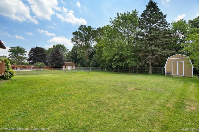 4220 England Beach Rd, White Lake, MI 48383 - fenced backyard with a storage shed and view of wooded area
