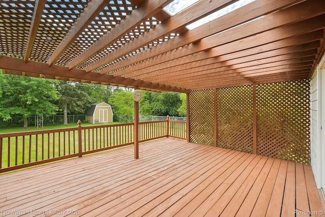 4220 England Beach Rd, White Lake, MI 48383 - wooden deck with a storage shed, a fenced backyard, a pergola, and view of wooded area