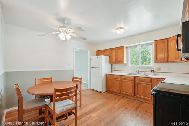 4220 England Beach Rd, White Lake, MI 48383 - kitchen featuring freestanding refrigerator, stove, light wood-type flooring, a ceiling fan, and light countertops