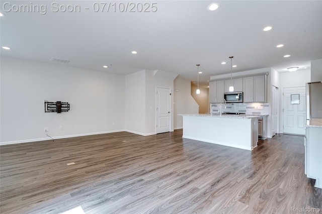43433 Chancellor Ln, Novi, MI 48375 - kitchen featuring appliances with stainless steel finishes, wood finished floors, recessed lighting, tasteful backsplash, and open floor plan