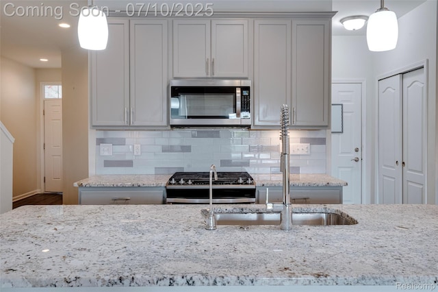 43433 Chancellor Ln, Novi, MI 48375 - kitchen with appliances with stainless steel finishes, light stone countertops, gray cabinetry, backsplash, and recessed lighting